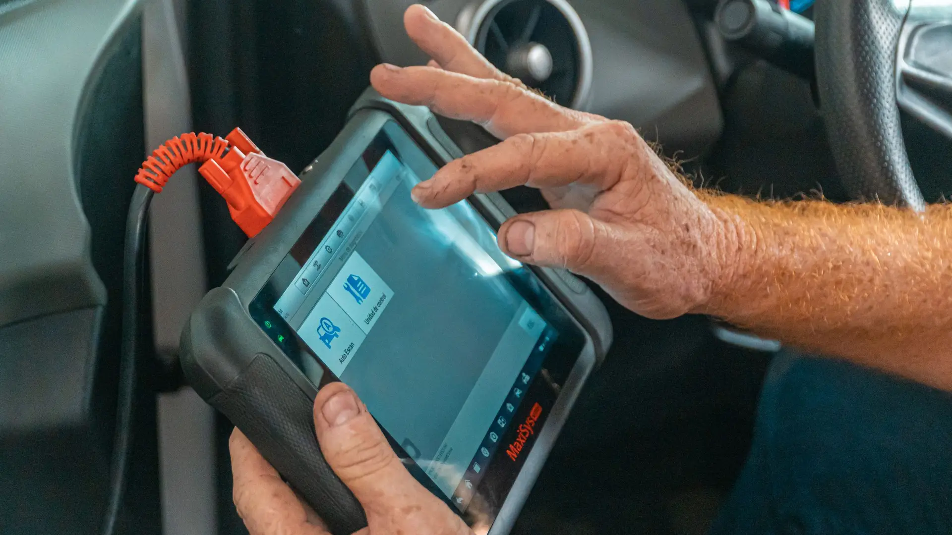 Técnico conectando una máquina de diagnosis a un coche