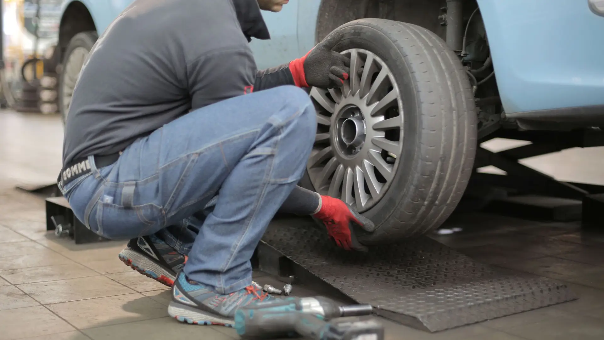 Mecánico cambiando la rueda de un coche en un taller de neumáticos